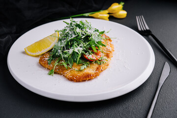 Traditional chicken schnitzel with arugula and lemon