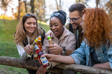 Multietnical group of young people in the nature, havig a great time and drinking beer.
Afro american people