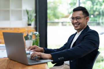 Portrait of a business man using laptop computer at office.