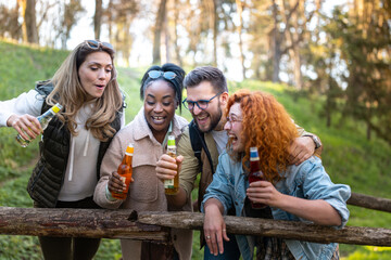 Multietnical group of young people in the nature, havig a great time and drinking beer.
Afro american people