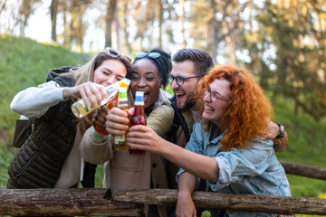 Multietnical group of young people in the nature, havig a great time and drinking beer.
Afro american people