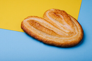 Puff pastry cookie on blue and yellow background