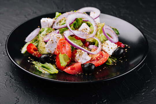 Greek Salad In Black Bowl On Stone