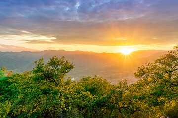 graet highland landscape with scenic view from mountain to below to a walley with majectic mountains and scenic cloudy sunset on background