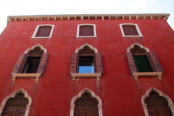 facade of a medieval red building with windows in Venice, Italy