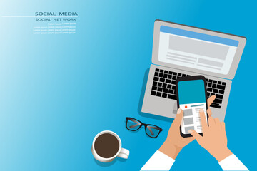 Social media, Social network concept.Hand holding the Mobile phone with laptop,  eye glass and coffee cup on work place.