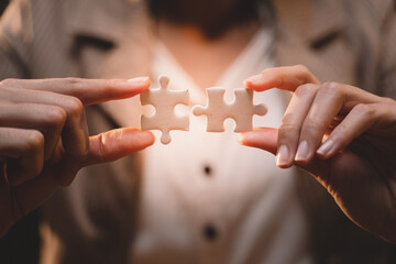 Close-up of business hands connecting jigsaw puzzle, success and goal achievement, the last jigsaw...