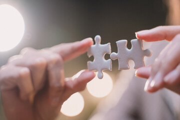 Close-up of business hands connecting jigsaw puzzle, success and goal achievement, the last jigsaw is the link of all the pieces. strategic planning or a solution for the management.