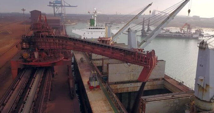 Shiploader Loading Iron Ore Onto Barge Dock At Paradip Port In Odisha, India. - aerial
