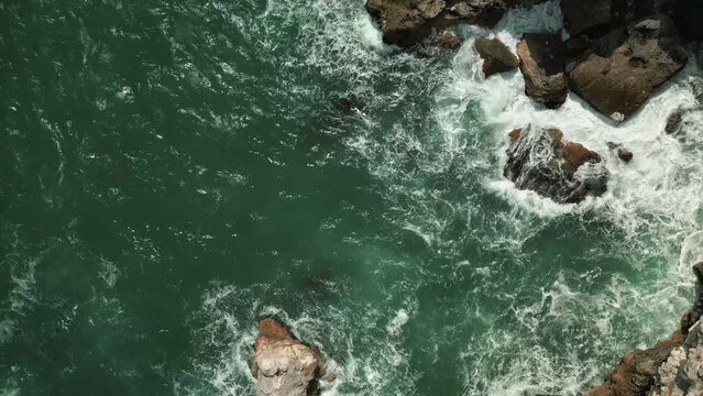 drone fly above stunning natural seascape with ocean sea waves crashing in to the coastline during a sunny day of summer