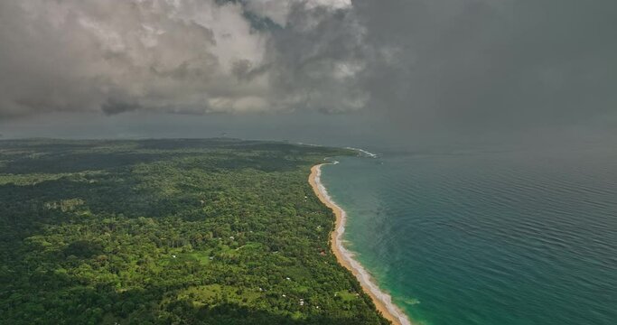 Bocas del Toro Panama Aerial v8 cinematic flyover capturing bluff beach, turquoise sea water and dense lush green vegetation with thick tropical clouds in the sky - Shot with Mavic 3 Cine - April 2022