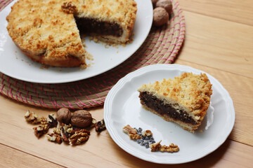 Traditional italian cake Sbrisolona cut in slices made with walnuts and chocolate on a plate on wooden table