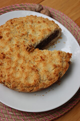 Traditional italian cake Sbrisolona cut in slices made with walnuts and chocolate on a plate on wooden table