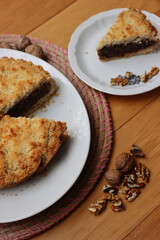 Traditional italian cake Sbrisolona cut in slices made with walnuts and chocolate on a plate on wooden table