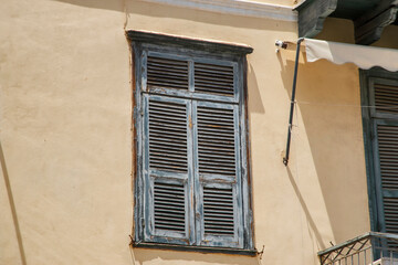 Windows with wooden shutters on facade of old Mediterranean house
