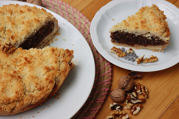 Traditional italian cake Sbrisolona cut in slices made with walnuts and chocolate on a plate on wooden table