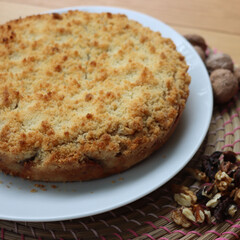 Traditional italian cake Sbrisolona made with walnuts and chocolate on a plate on wooden table