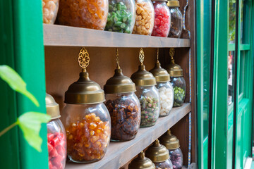Candy jars on the shelf of the candy shop in the street.