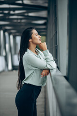 Beautiful business woman standing by the bridge next to business center