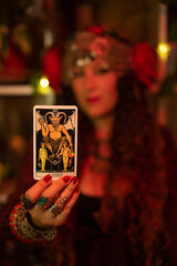 gypsy card dealer holding devil tarot card

