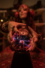 close-up of a fortune-teller's hands around her fortune-telling crystal ball with lightning bolts...