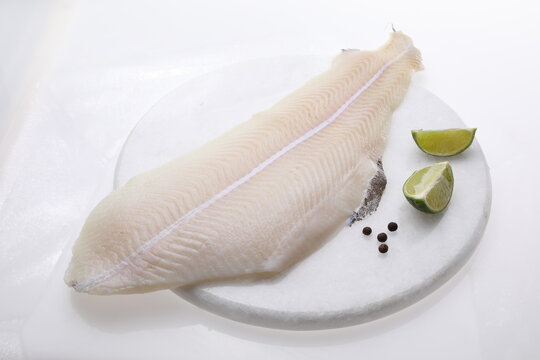 Lemon sole fillet on a white background, a packshot photo for fish shop, top view.