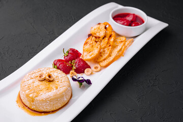 Brie cheese baked with nuts and strawberries