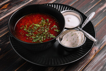 Appetizing dish borscht served with bread, lard slicrs and sour cream