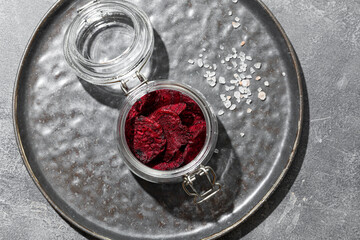 Fototapeta Beetroot chips in a jar on a gray background top view. Healthy vegetable chips, snack for vegetarians obraz