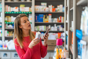 Profile shot of beautiful young woman shopping at pharmacy. Woman holding medication container...
