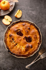 Halloween pie with funny pumpkin face carved on pie, top view. Autumn baking