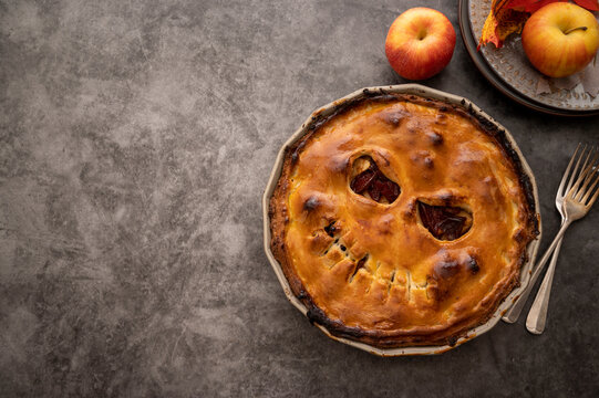 Halloween Pie With Funny Pumpkin Face Carved On Pie, Top View. Autumn Baking