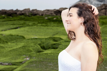 Naklejka premium woman on the coast with white dress holding her hair