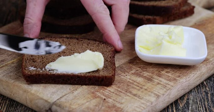 Making sandwiches with rye bread and butter, butter from milk and black rye bread