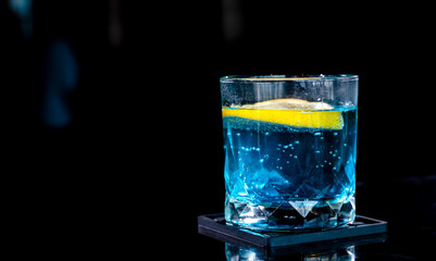 Close up glass of soda cocktail with piece lemon in bar and restaurant on black background , Bartender Concept