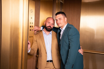 Beautiful adult gay couple hugging in the elevator. Love, passion and romantic relationship. The first date of two men.
