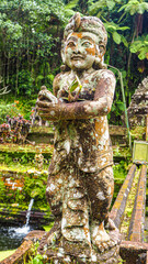 Statue with a fountain behind in Kwai Sebatu temple in Bali