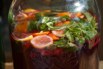 Large glass jars with soft drinks made from fresh fruits and berries.