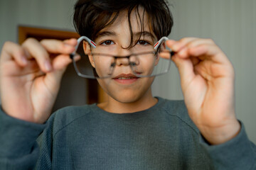 Portrait of a teenage boy with poor eyesight wearing glasses