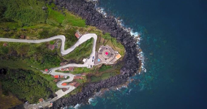 Drone descent towards ponta arnel lighthouse on a cliff on the island of Sao Miguel, Azores