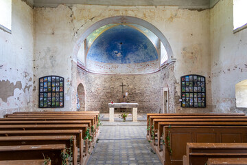 interior of the old abandoned church with stone walls, view from behind the pews to the presbytery...