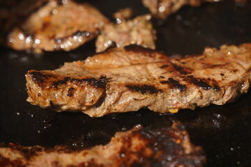 Roasting different pieces of beef for burgers and quesadillas.
