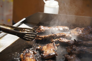 Roasting different pieces of beef for burgers and quesadillas.