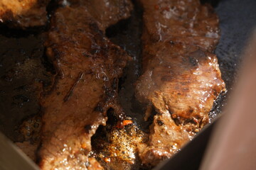 Roasting different pieces of beef for burgers and quesadillas.
