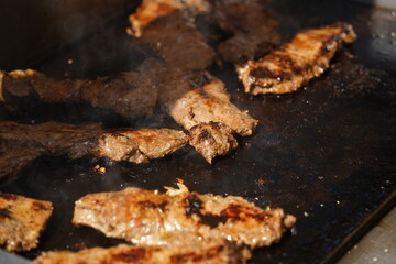 Roasting different pieces of beef for burgers and quesadillas.