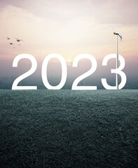 2023 white text with wind turbine on green grass field over aerial view of cityscape at sunset, vintage style, Happy new year 2023 ecological cover concept