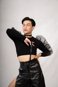 A Transgender Man Poses In A Black Dress With An Elegance Face And Black Hair