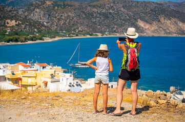 Tourists photographing a sailboat boat in Paleochora, Crete, Greece.