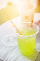 Lemonade apple in a plastic glass. Summer cocktail with green apple and ice