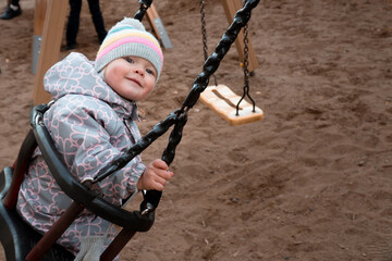 Baby on swing in winter clothes